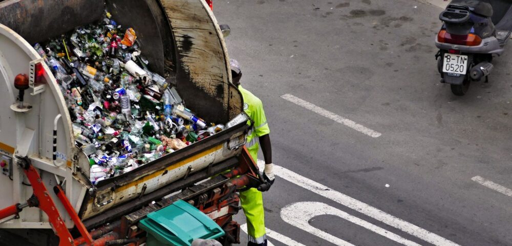 people collecting trash in garbage truck
